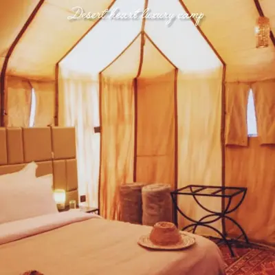 a hat sitting on top of a bed in a room at Desert Heart Luxury Camp in Merzouga