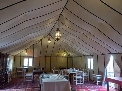 a large tent with tables and chairs in it at Desert Heart Luxury Camp in Merzouga