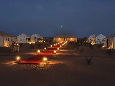 a long row of lights in the desert at night at Desert Heart Luxury Camp in Merzouga