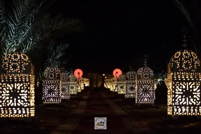 a row of lights at night with palm trees at Luxury oasis camp in Merzouga