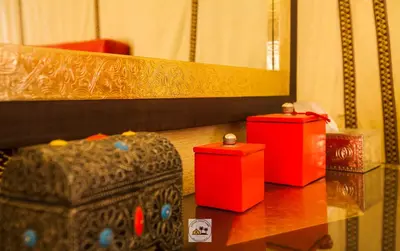 three red boxes sitting on a table in front of a mirror at Luxury oasis camp in Merzouga