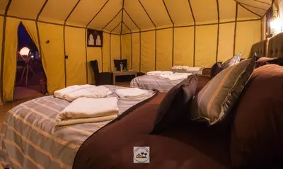 a room with two beds in a tent at Luxury oasis camp in Merzouga