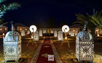 a group of lighted objects in a field at night at Luxury oasis camp in Merzouga