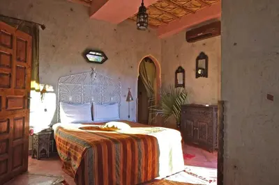 a bedroom with a bed with a blanket on it at Sawadi Ecolodge in Skoura