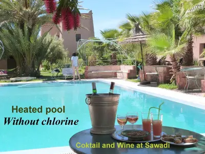 a table with drinks next to a swimming pool at Sawadi Ecolodge in Skoura