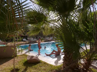 a group of people playing in a swimming pool at Sawadi Ecolodge in Skoura