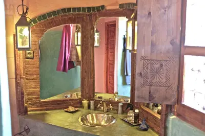 a bathroom with a sink and a large mirror at Sawadi Ecolodge in Skoura