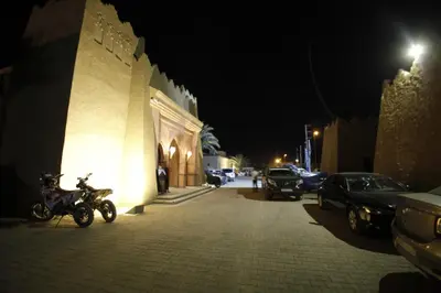 a motorcycle parked next to a building at night at Belere Arfoud in Erfoud