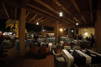 a restaurant with tables and chairs and people at night at Belere Arfoud in Erfoud