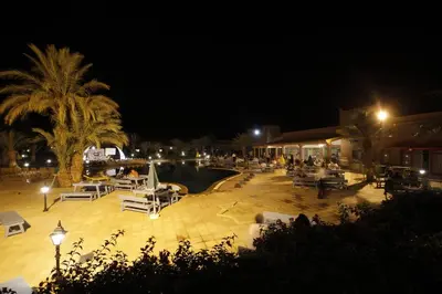 a resort with a swimming pool at night at Belere Arfoud in Erfoud