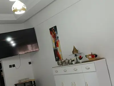 a kitchen with a white refrigerator and a tv at Ryan 3 in Fès