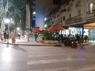 a group of people walking down a street at night at Ryan 3 in Fès