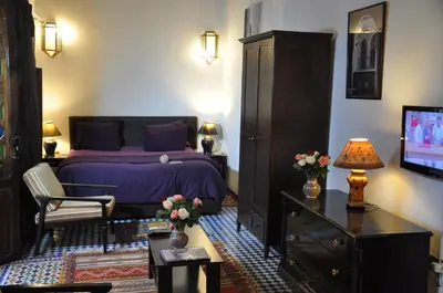 a bedroom with a purple bed and a tv at Riad Adarissa in Fès