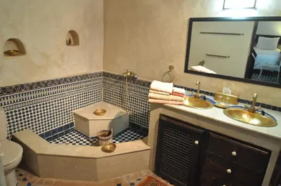 a bathroom with a sink and a toilet and a mirror at Riad Adarissa in Fès