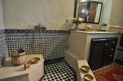 a bathroom with a sink and a toilet and a tub at Riad Adarissa in Fès