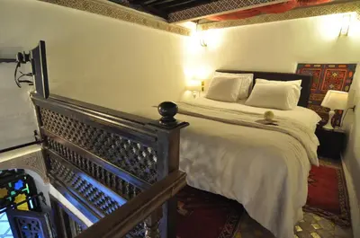 a bedroom with a large bed with white sheets at Riad Adarissa in Fès