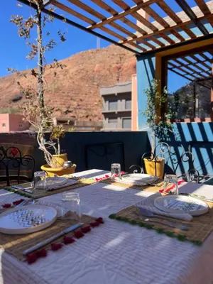 a table with plates and glasses on top at Hiking Nomads Guesthouse in Tamellalt