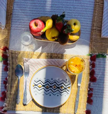 a table with a plate and a bowl of fruit at Hiking Nomads Guesthouse in Tamellalt
