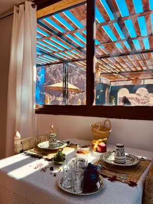 a table with two plates of food and a window at Hiking Nomads Guesthouse in Tamellalt