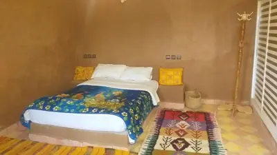 a bedroom with a bed and a rug at Auberge Camping BOUGAFER Tamtetoucht in Tamtetoucht