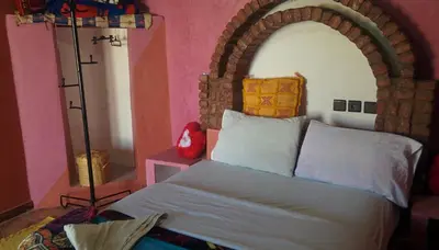 a bedroom with a large bed with an arch above it at Auberge Camping BOUGAFER Tamtetoucht in Tamtetoucht