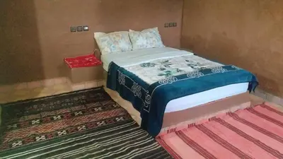 a small bedroom with a bed and a rug at Auberge Camping BOUGAFER Tamtetoucht in Tamtetoucht