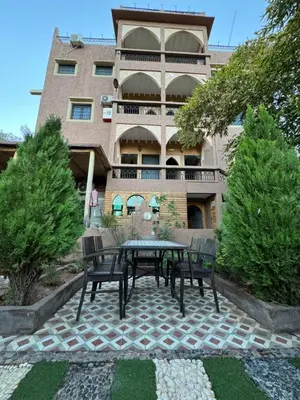 a patio with a table and benches in front of a building at Dar Diafa Kaltom in Ouzoud