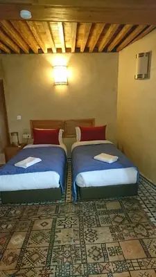 two beds sitting in a room with at Riad jasmins & Spa in Fès