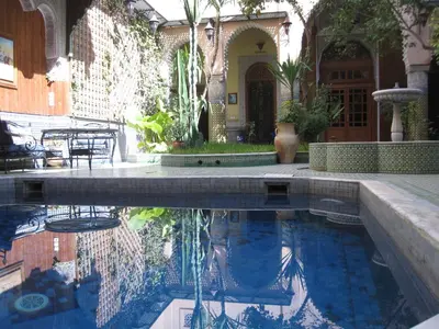 a swimming pool in front of a house at Riad Jaouhara in Fès