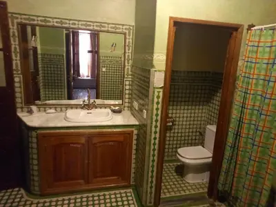 a bathroom with a sink and a toilet and a mirror at Riad Jaouhara in Fès