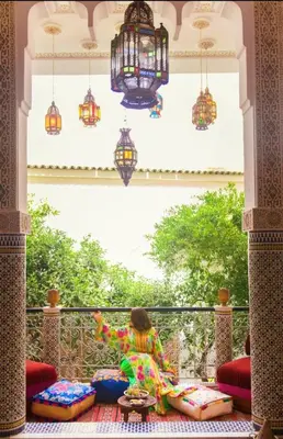 a young girl sitting on a balcony looking out a window at Riad Lalla Fatima in Fès