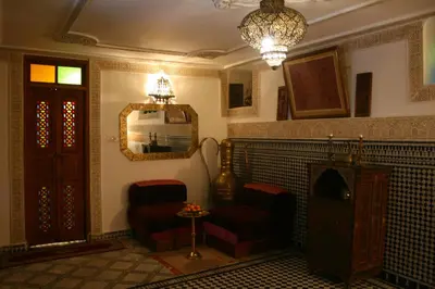 a living room with a fireplace and a mirror at Riad Lalla Fatima in Fès
