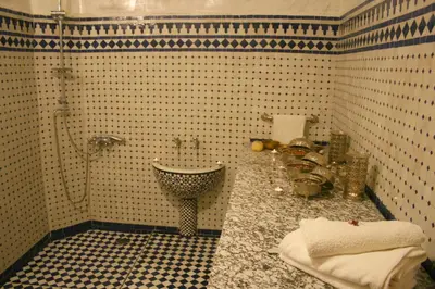 a tiled bathroom with a sink and a shower at Riad Lalla Fatima in Fès