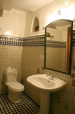 a bathroom with a sink and a toilet and a mirror at Riad Lalla Fatima in Fès