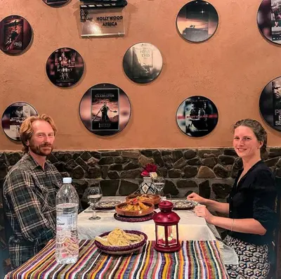 a man and woman sitting at a table in a restaurant at Riad Chay & Boutique in Ouarzazate