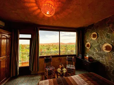 a bedroom with a bed and a large window at Riad Chay & Boutique in Ouarzazate