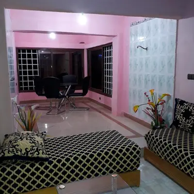 a living room with a bed and a table and chairs at Oasispalmares in Er Rachidia
