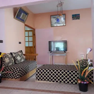 a living room with a couch and a tv at Oasispalmares in Er Rachidia