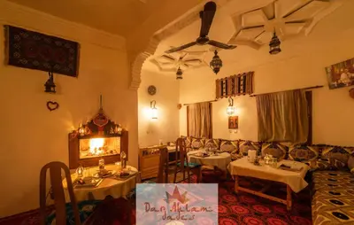 a restaurant with tables and chairs in a room at Dar Ahlam Dades Hotel in Aït Ouaddar