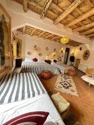 two beds in a room with pumpkins on the floor at Dar Ahlam Dades Hotel in Aït Ouaddar