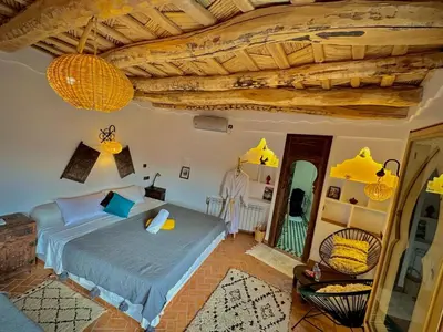 a bedroom with a bed and a wooden ceiling at Dar Ahlam Dades Hotel in Aït Ouaddar