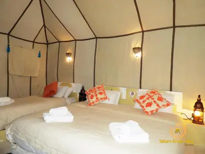 a bedroom with two beds in a tent at Luxury Sahara Dream Camp in Merzouga