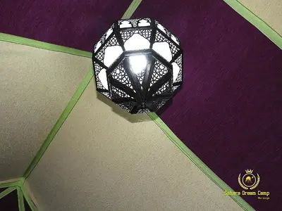 a black chandelier hanging on a wall at Luxury Sahara Dream Camp in Merzouga