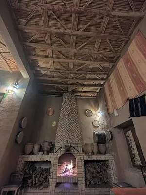 a living room with a fireplace in a house at Maison Merzouga Guest House in Merzouga