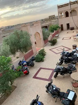a group of motorcycles parked in front of a building at Maison Merzouga Guest House in Merzouga