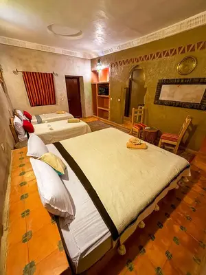 a bedroom with two beds in a room at Maison Merzouga Guest House in Merzouga