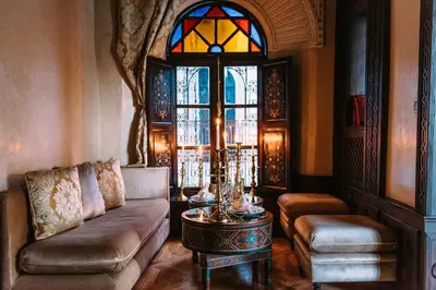 a living room with a couch and a stained glass window at Riad Maison Bleue and Spa in Fès