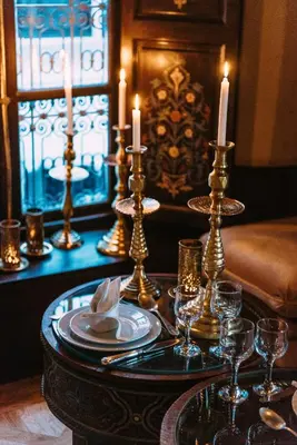 a table with two candles and plates and wine glasses at Riad Maison Bleue and Spa in Fès