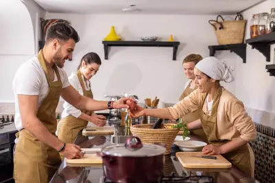 a group of people in a kitchen preparing food at Riad Maison Bleue and Spa in Fès
