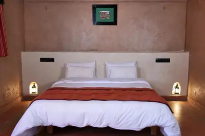 a bedroom with a large white bed with two pillows at Kasbah Zitoune in Ouarzazate